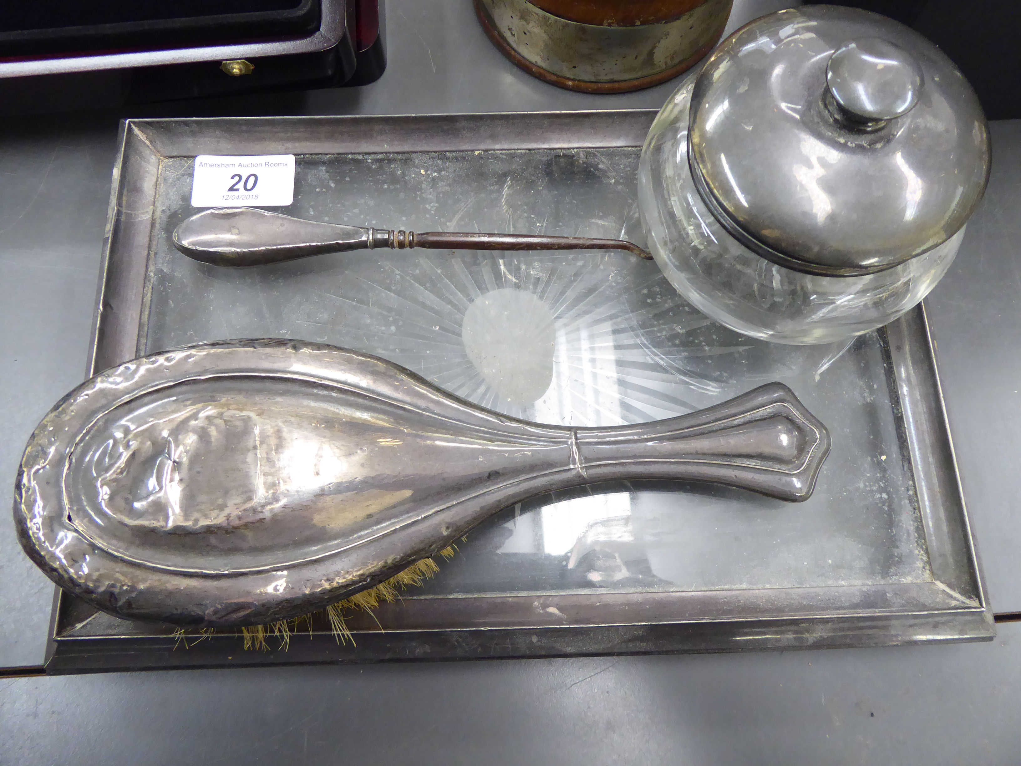 An early 20thC silver framed dressing table tray with a cut-glass panel; a silver backed hairbrush;