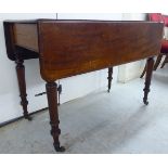 A late Victorian mahogany Pembroke table with a frieze drawer, raised on turned,
