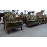 An early/mid 20thC walnut framed bergere suite, comprising a three seater settee and two armchairs,