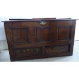 A late 18thC oak coffer with a hinged lid, over a tri-panelled front and two frieze drawers,