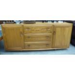 An Ercol light coloured elm sideboard, comprising three central drawers,