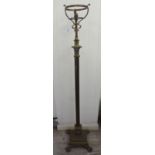 An early 20thC brass lamp standard (converted to electricity) with a reservoir frame,