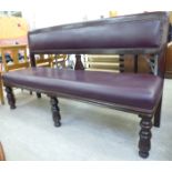 A mid/late 19thC mahogany framed settle with a level, stud upholstered,