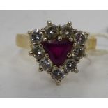 An 18ct gold ring with a heart shaped bezel and a central ruby,