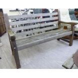 A modern teak garden bench with a slatted back and seat 60''w CA