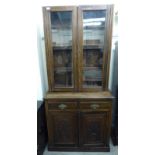 A late Victorian walnut cabinet bookcase, the upper part enclosed by a pair of panelled doors,