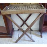 An early 20thC bleached mahogany butler's tray with a latticed platform and opposing cut-out