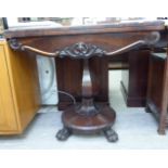 An early Victorian rosewood card table, the rotating foldover top enclosing a baise lined interior,