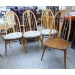A set of five Ercol light coloured beech and elm framed high hoop and spindled back dining chairs
