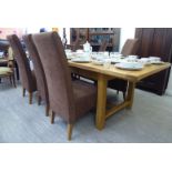 A modern light oak extending refectory style dining table, raised on chamfered, square legs,