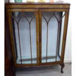 A 1930s walnut bow front display cabinet with a pair of glazed doors,