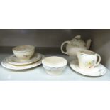 A Susie Cooper china tea set for one, decorated with flora sprigs,