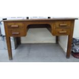 A Crusader light oak office kneehole desk, the four drawers with block handles,