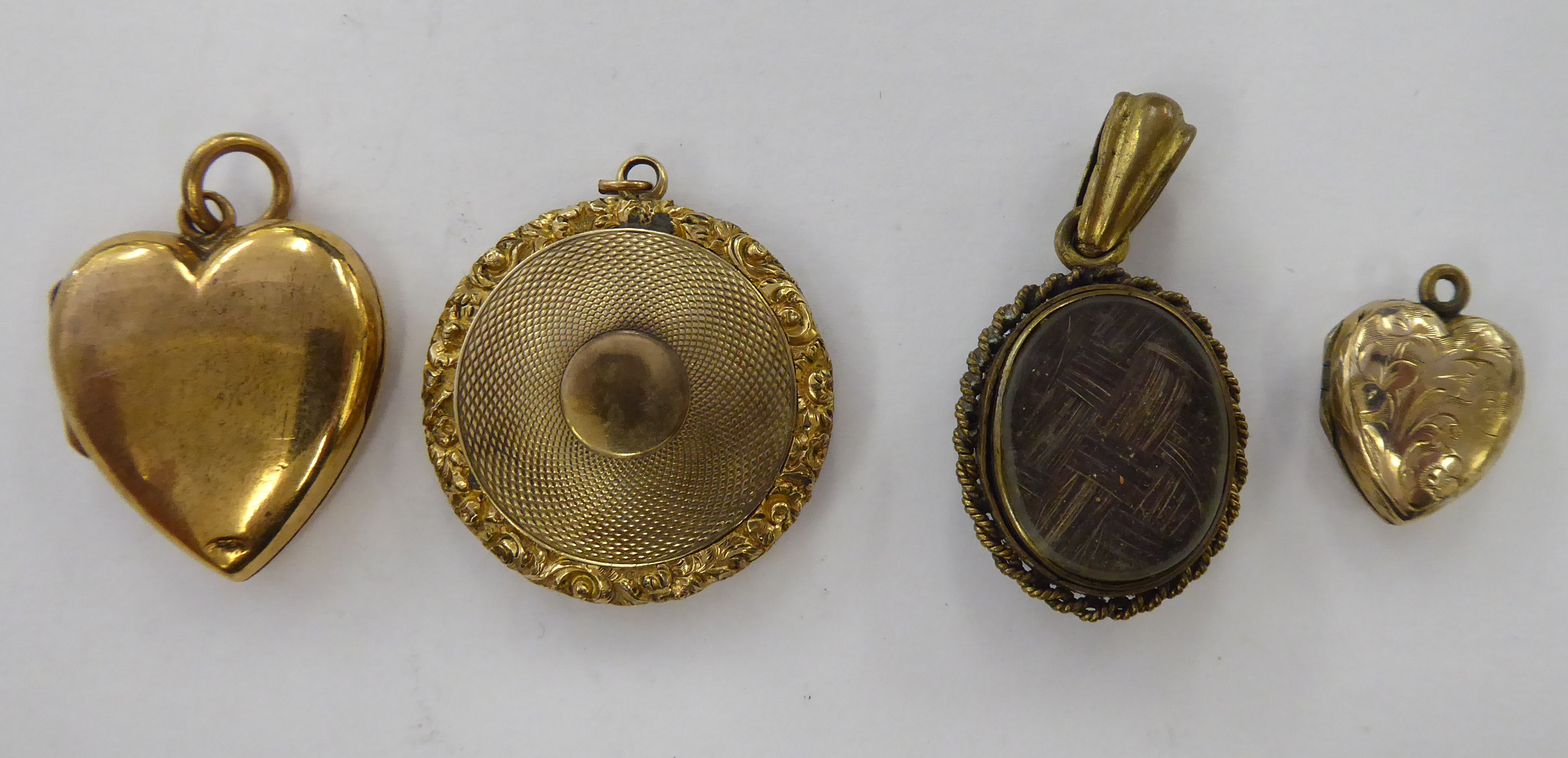 Four dissimilar 'antique' yellow metal lockets: to include one of heart design with floral engraved - Image 2 of 2