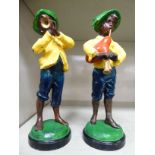 A pair of early 20thC Continental, painted spelter urchin figures, one playing a trumpet,