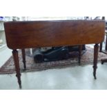 A late Victorian mahogany Pembroke table with a frieze drawer, raised on turned,