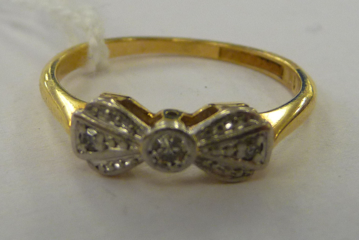 An 'antique' 18ct gold and platinum ring, fashioned as a bow tie,