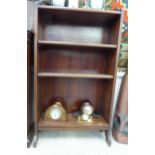 An Edwardian mahogany open front bookcase with a marquetry shell motif on the galleried upstand,