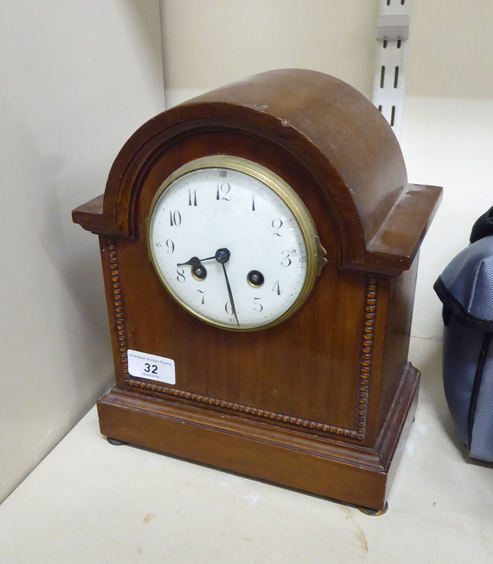 An early 20thC mahogany cased mantel clock with a round arch and beaded ornament,
