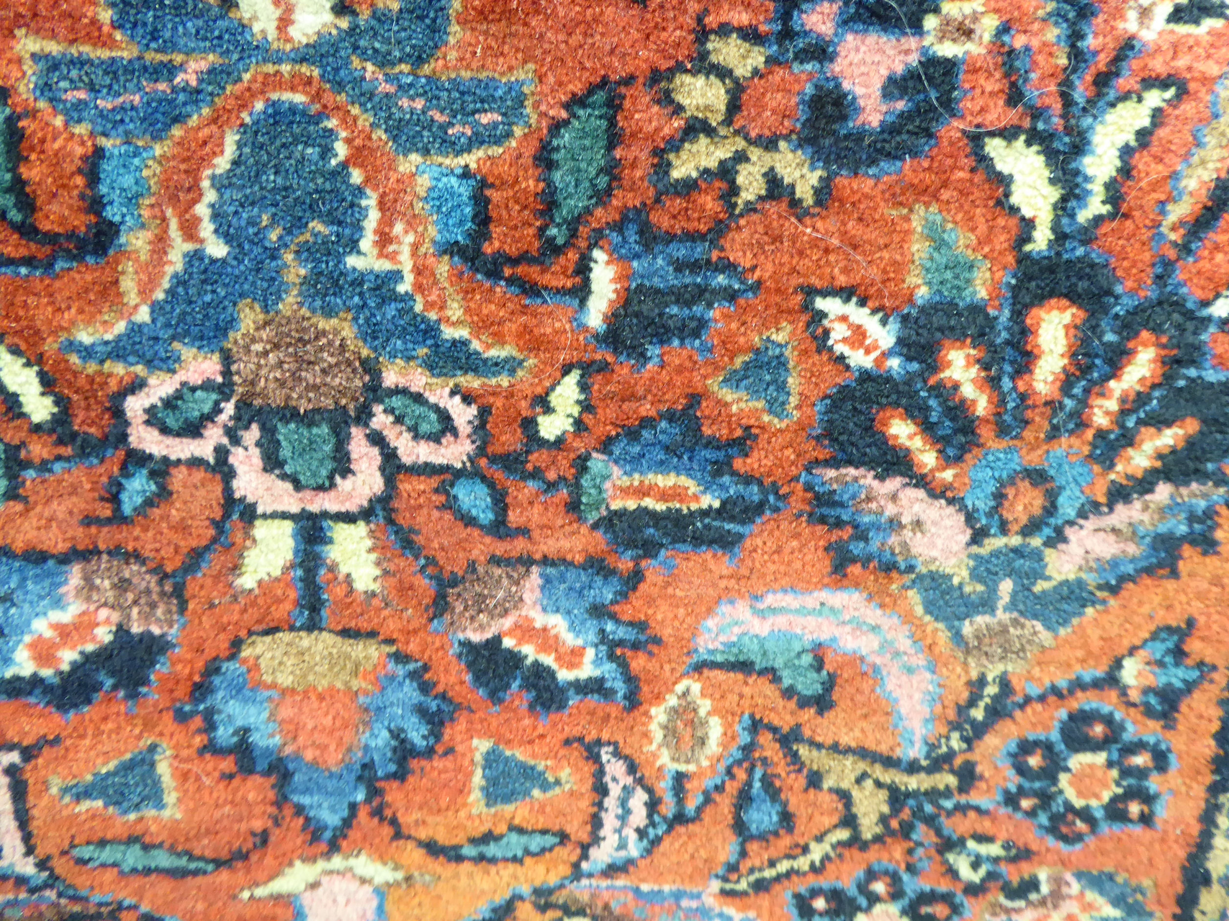 A Persian rug decorated with stylised flora on a red ground 31'' x 59'' SL - Image 2 of 3