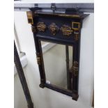 An early 20thC pier glass, the mirror set in a black painted and gilded,