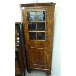 A 20thC walnut veneered corner cabinet with an astragal glazed door and a panelled door,