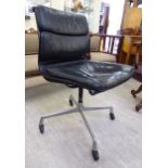 A Herman Millar chair with a cushioned black hide upholstered back and seat,