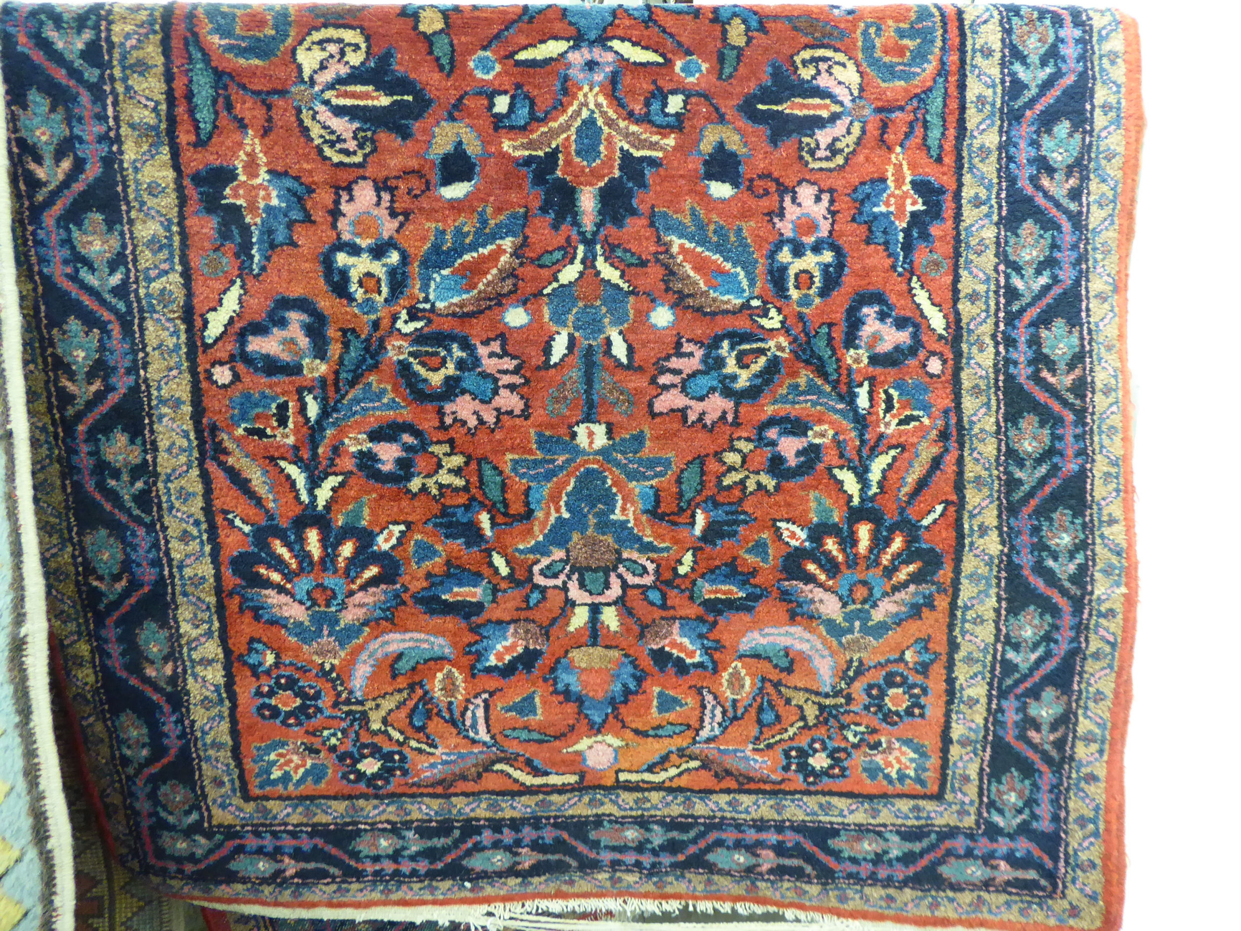 A Persian rug decorated with stylised flora on a red ground 31'' x 59'' SL