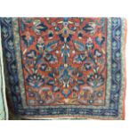 A Persian rug decorated with stylised flora on a red ground 31'' x 59'' SL