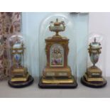 A late 19thC French cast gilt metal and porcelain cased clock garniture, featuring an urn crest,