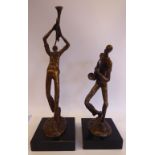 Two cast and patinated bronze figures, one playing the trumpet,