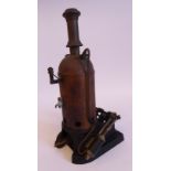An early 20thC black painted copper and iron live steam model, stationary bottle engine,