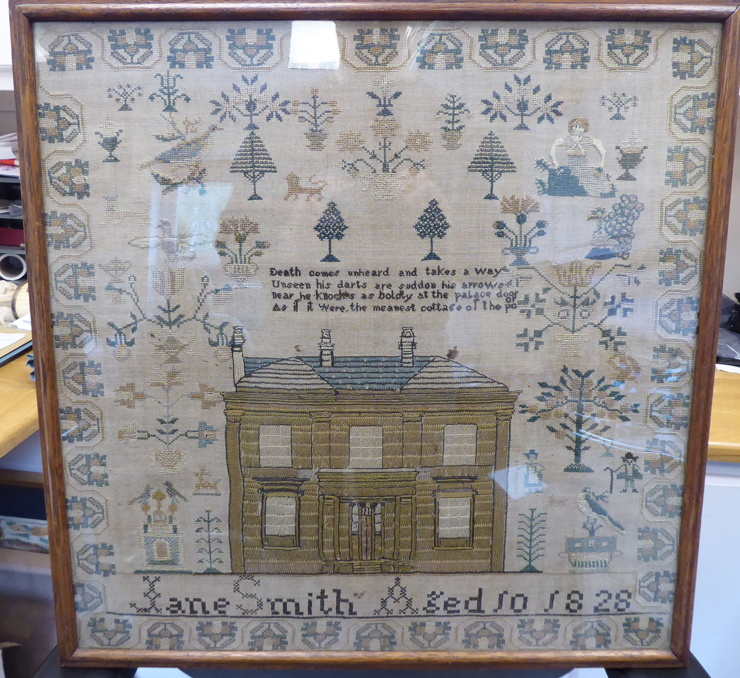 A George IV sampler, featuring a two storey house, stylised trees, birds and border ornament,
