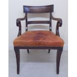 A Regency mahogany framed elbow chair with a curved reed carved bar crest and horizontal splat,