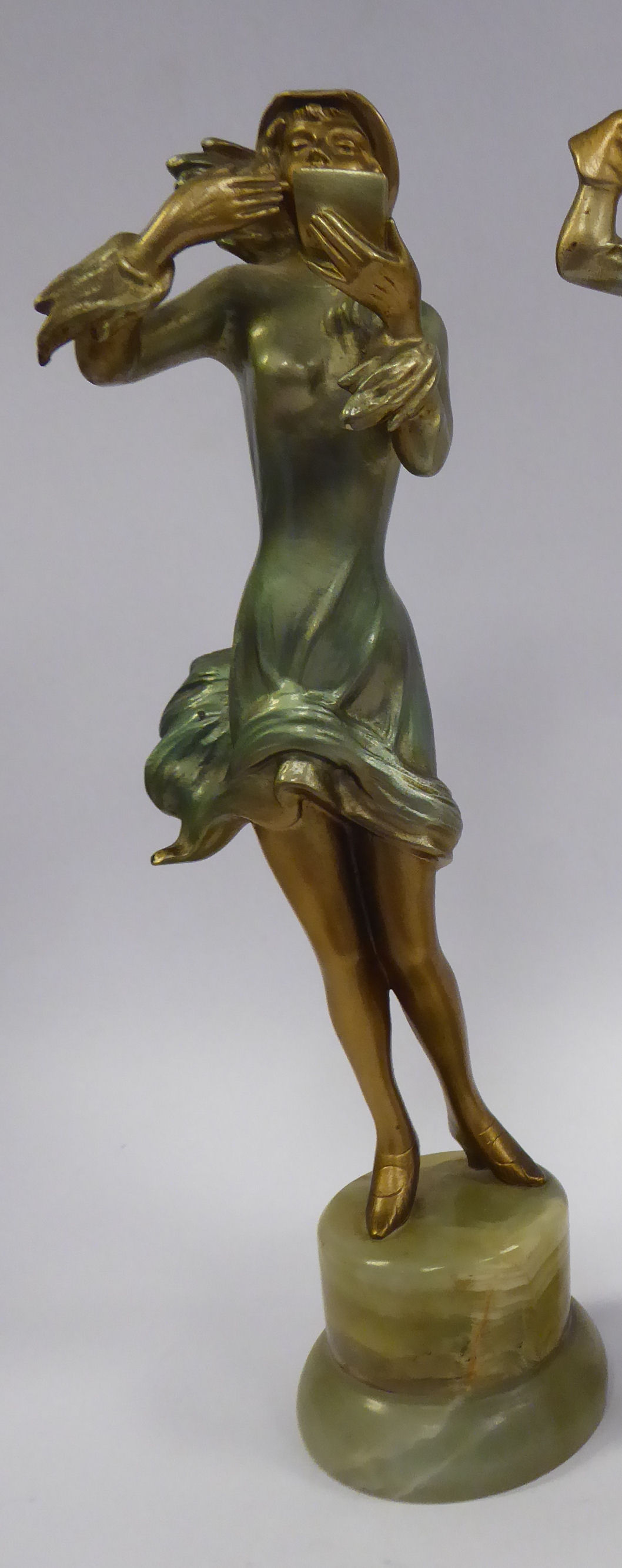 A late 1920s/early 1930s painted cold cast figure, a fashionable young woman, wearing a bonnet,