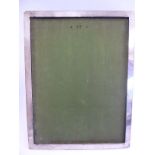 A silver photograph frame of wide, plain strip design,