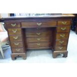 A George III mahogany architect's kneehole desk, the top with a mitred border,