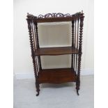 An early Victorian rosewood serpentine front whatnot with a fretworked gallery, over two undertiers,