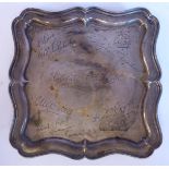 A silver salver with a raised, serpentine outlined piecrust border,