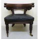 A William IV mahogany framed library chair with a low, round, scroll and reed carved back,