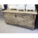 An early 20thC bleached and cream colour wash painted oak chest with a hinged lid and straight