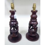 A pair of modern African carved hardwood table lamps, fashioned as a working native couple,