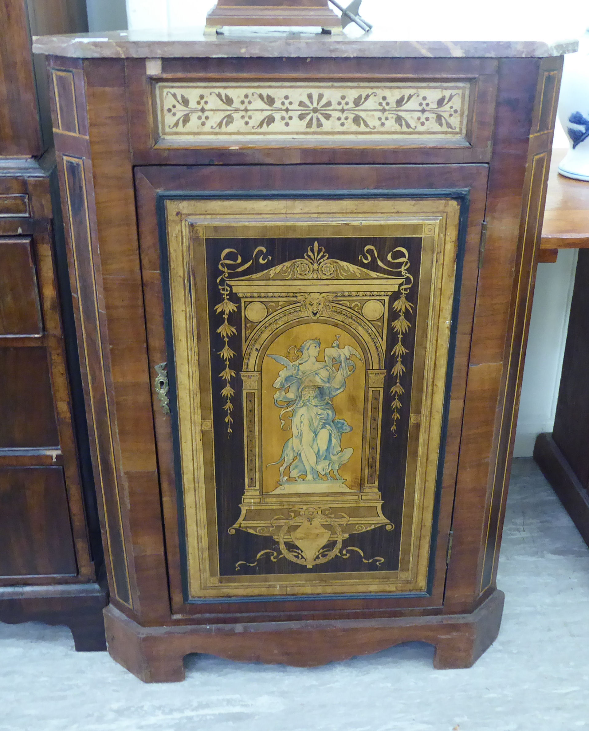 An early 20thC walnut veneered standing corner cupboard with a marble top,