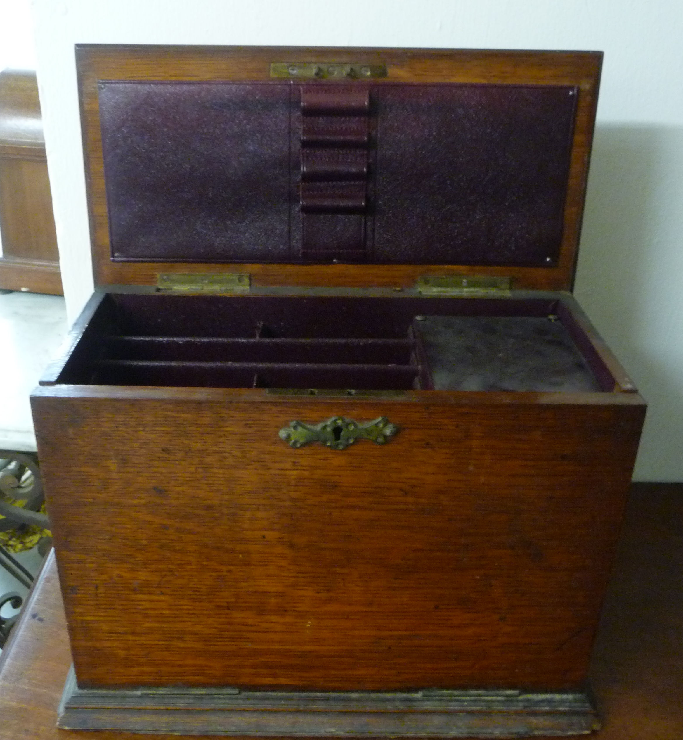 An early 20thC light oak, desktop stationery cabinet with a rising top, fall front,