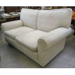 A modern two seater settee, upholstered in textured two tone cream coloured fabric,