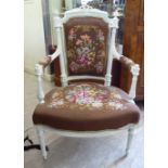 An early 20thC French, later white painted, carved walnut, showwood framed, open arm chair,