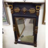 An early 20thC pier glass, the mirror set in a black painted and gilded,