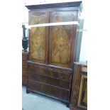 A late Victorian Georgian design walnut linen press with a dentil moulded cornice,