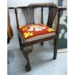 A 1920s stained oak corner chair, having opposing lath splats and a horseshoe shaped back,