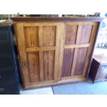 A mid 20thC waxed pine gun cabinet with a moulded cornice, over a pair of sliding doors,